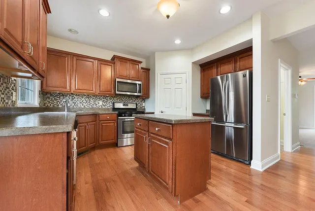 a kitchen with stainless steel appliances granite countertop a refrigerator stove and sink