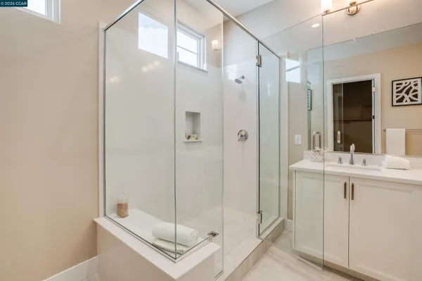 a bathroom with a shower sink and mirror