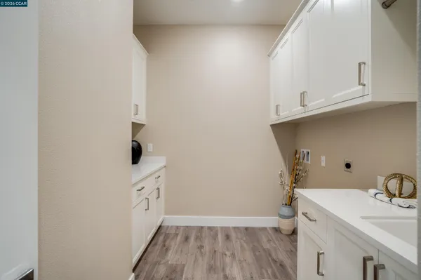 a view of a kitchen with white cabinets and sink