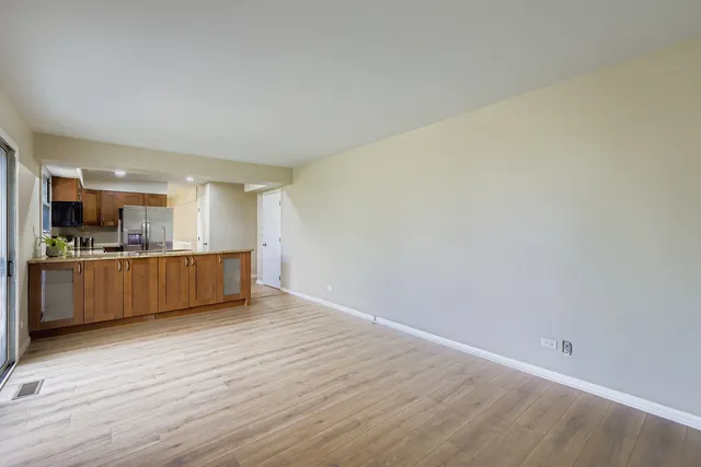 a view of kitchen with wooden floor and electronic appliances