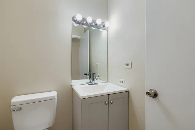 a bathroom with a toilet a sink and mirror