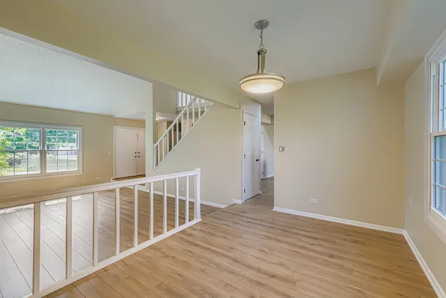 a view of a hallway with wooden floor and chandelier