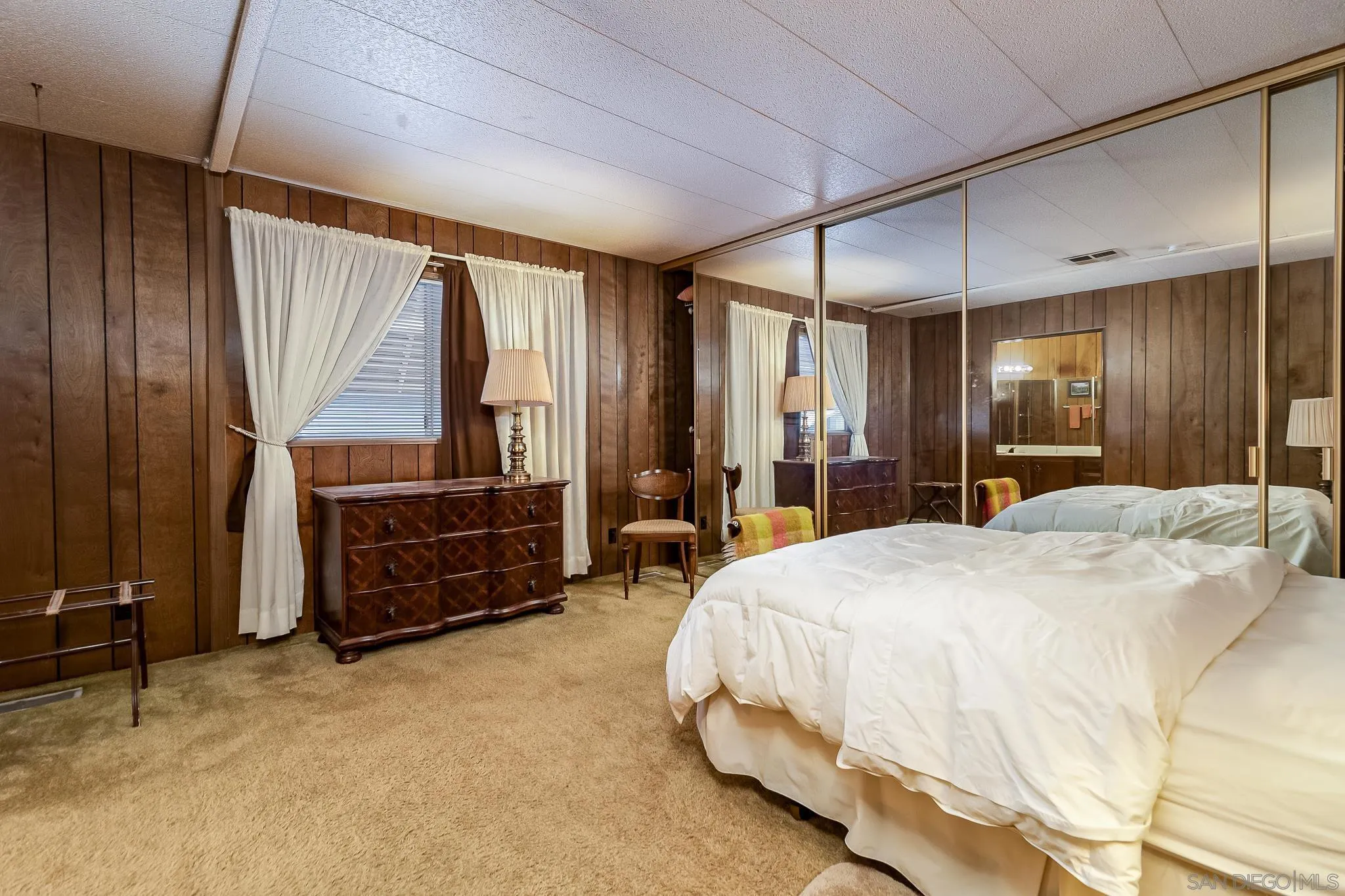 7467 Mission Gorge Road, Unit SPC 291 Santee, CA 92071 - Photo 20 of 40 a spacious bedroom with a bed a dresser and a chandelier