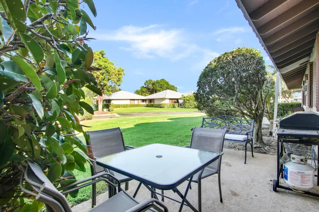 a view of a house with a yard and sitting area