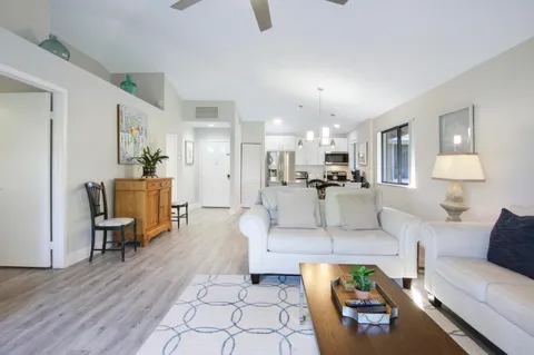 a living room with furniture and view of kitchen