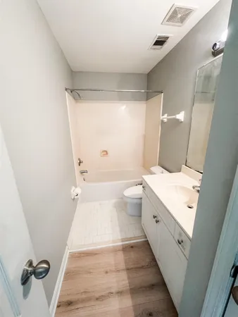 a spacious bathroom with a granite countertop sink a toilet a mirror and shower