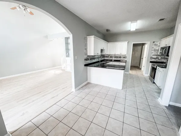 a kitchen with granite countertop a sink and a stove top oven