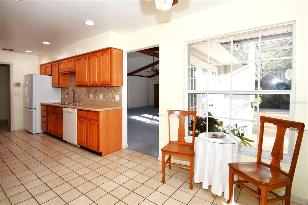 611 Old Eustis Road Mount Dora, FL 32757 - Photo 20 of 45 a kitchen with stainless steel appliances granite countertop a refrigerator a stove a sink and a dining table with the view of kitchen