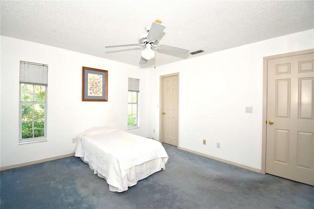 611 Old Eustis Road Mount Dora, FL 32757 - Photo 31 of 45 a spacious bedroom with a bed and a chandelier