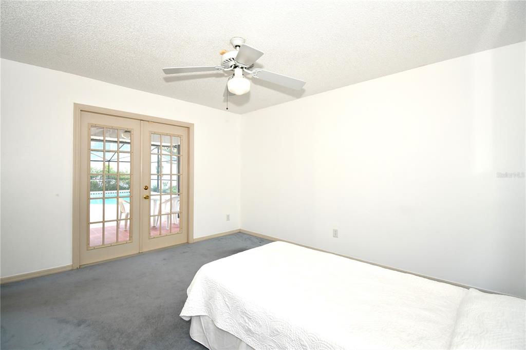 611 Old Eustis Road Mount Dora, FL 32757 - Photo 33 of 45 a spacious bedroom with a bed and a chandelier