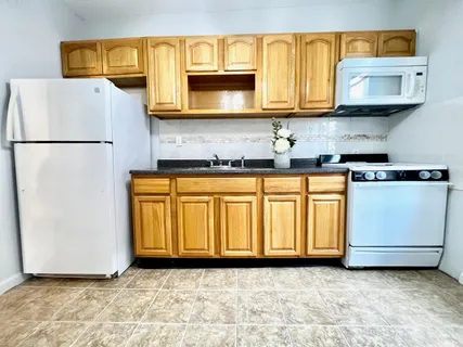 a kitchen with stainless steel appliances granite countertop a refrigerator a stove a sink and white cabinets