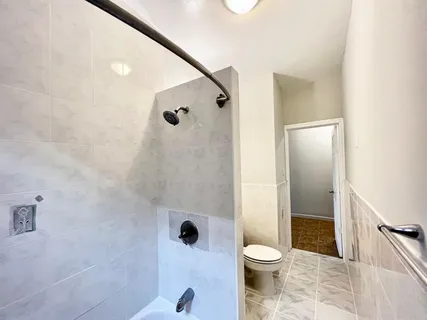 a bathroom with a toilet and a shower