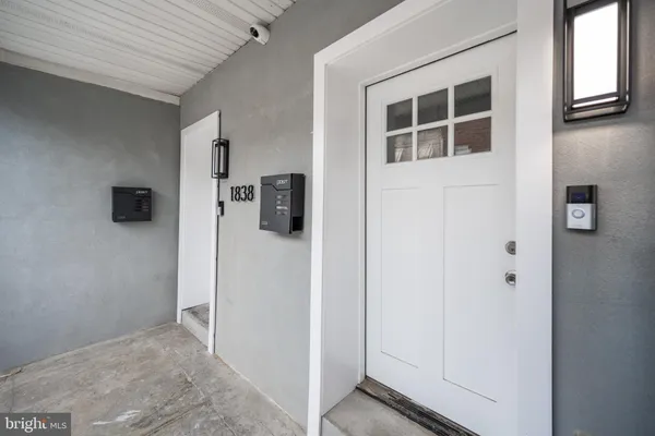 a view of a hallway with wooden cabinets and a refrigerator
