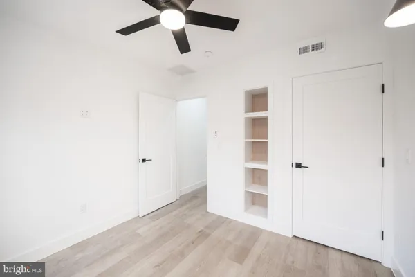 a view of empty room with wooden floor and window