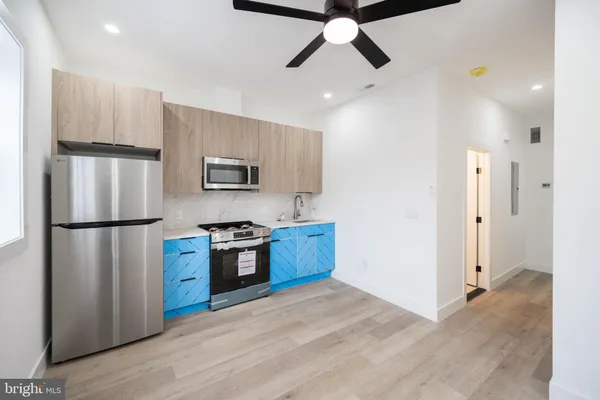 a kitchen with stainless steel appliances granite countertop a refrigerator a stove a microwave and white cabinets