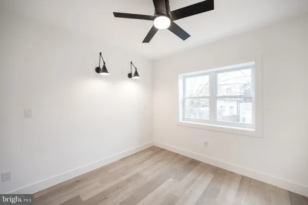 an empty room with a window and a ceiling fan