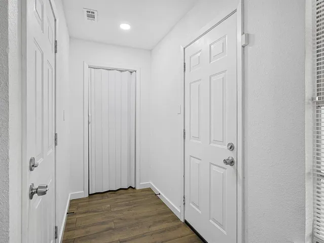 a view of a hallway with wooden floor