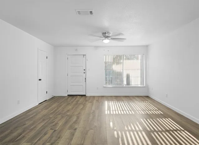wooden floor in an empty room with a window