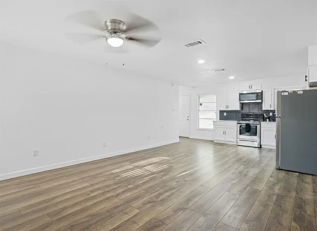 a view of kitchen with refrigerator microwave and stove