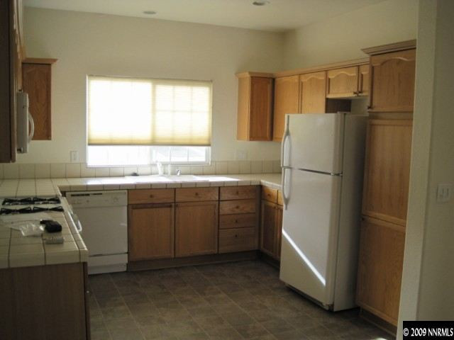 1875 San Pablo Drive Reno, NV 89521 - Photo 3 of 9 a kitchen with a refrigerator sink stove and cabinets