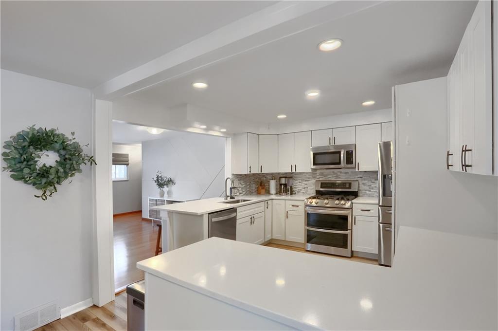 9652 Shirley Drive Allison Park, PA 15101 - Photo 12 of 49 a kitchen with stainless steel appliances a stove top oven a sink dishwasher and a refrigerator with wooden floor