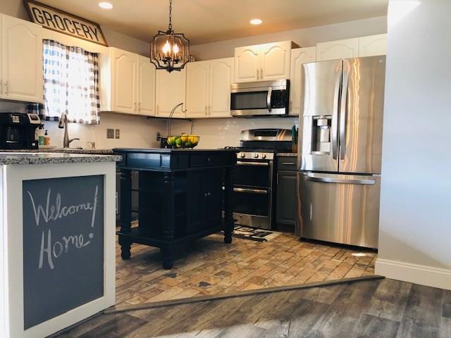 277 Holyoke Road Butler, PA 16001 - Photo 7 of 24 Refinished kitchen cabinets with granite counter tops, glass tile backsplash, and stainless steel appliances.