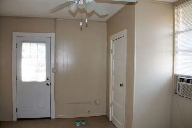 an empty room with windows closet and chandelier fan