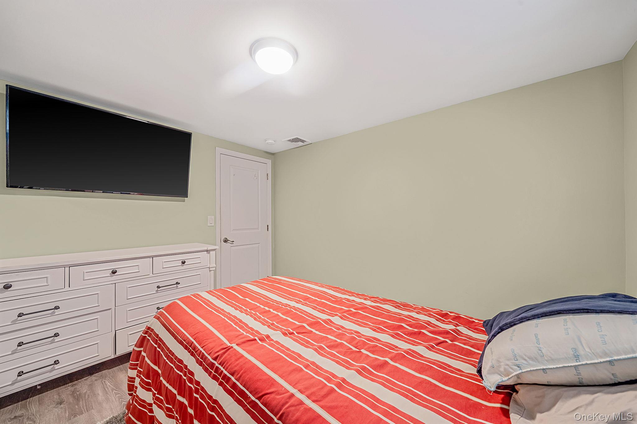 110 Stephen Road Bayport, NY 11705 - Photo 30 of 39 a bedroom with a bed and a flat screen tv
