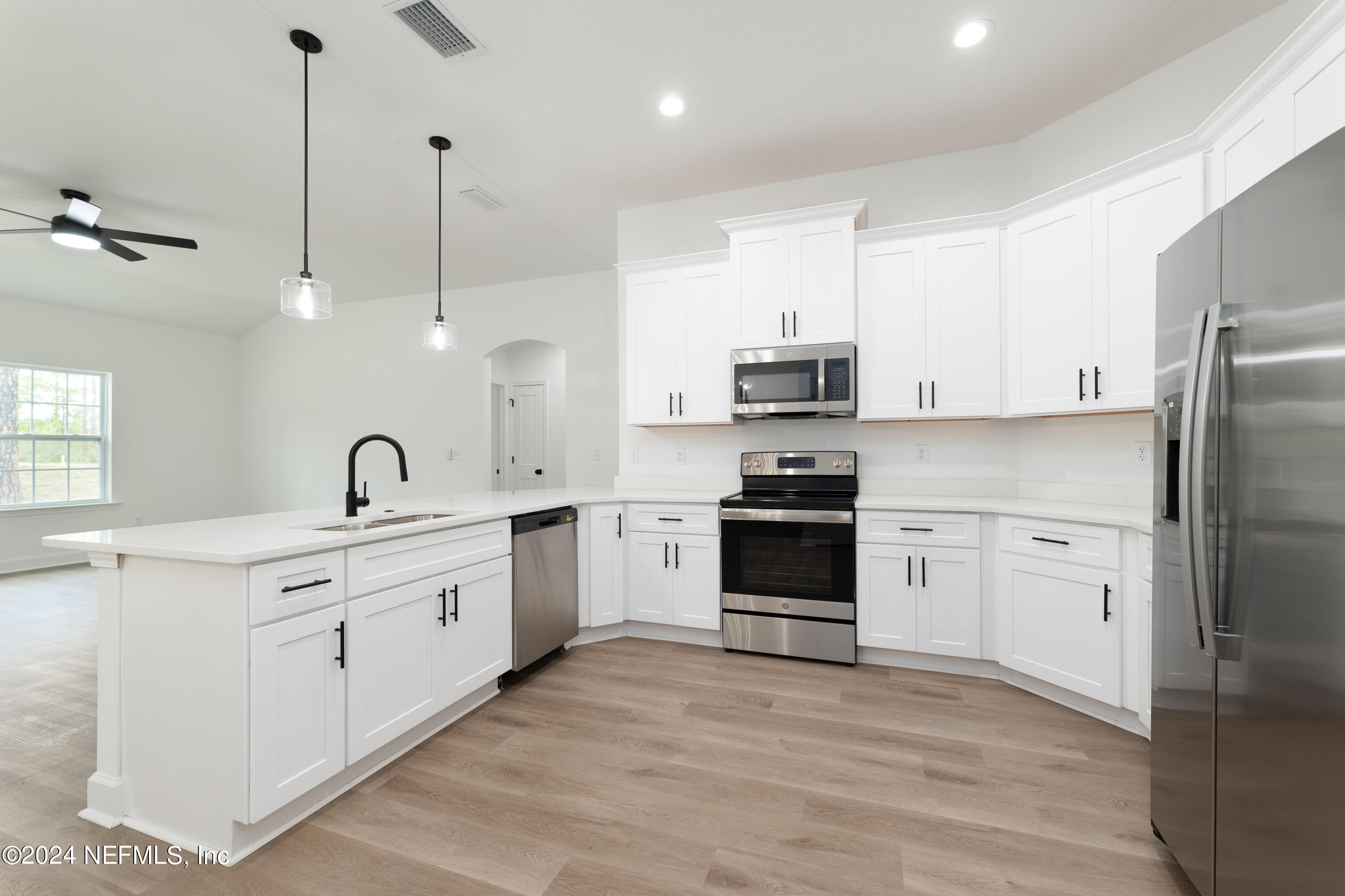 489 Kay Road Middleburg, FL 32068 - Photo 13 of 36 a kitchen with white cabinets and stainless steel appliances