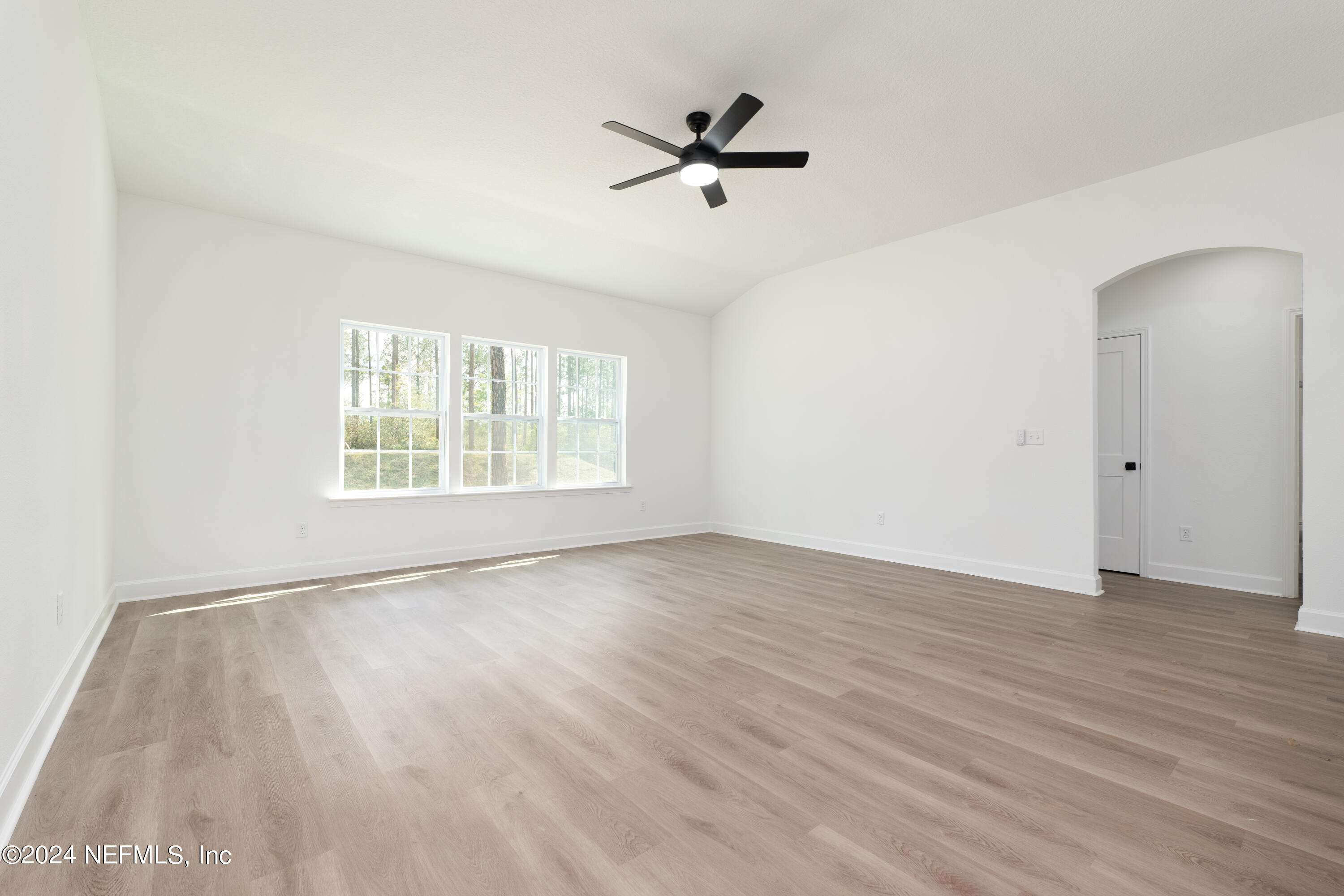 489 Kay Road Middleburg, FL 32068 - Photo 17 of 36 an empty room with wooden floor fan and windows