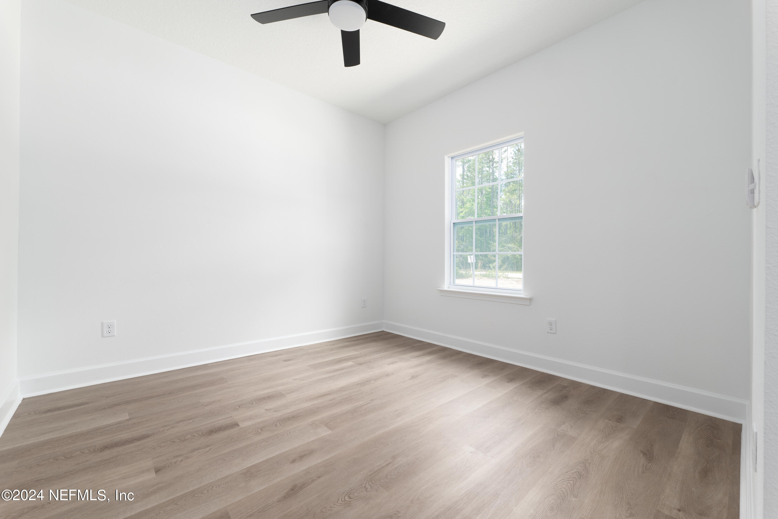 489 Kay Road Middleburg, FL 32068 - Photo 6 of 36 an empty room with wooden floor fan and windows