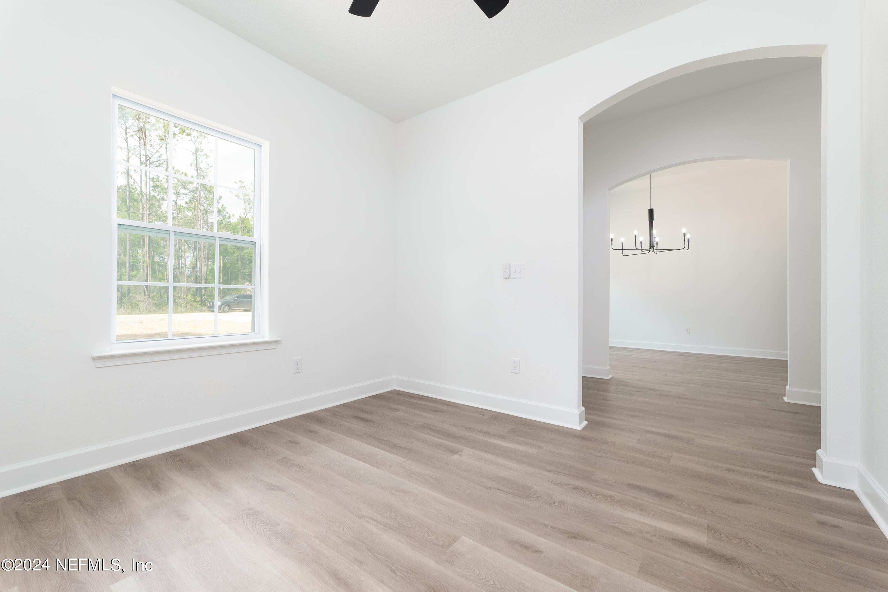 489 Kay Road Middleburg, FL 32068 - Photo 7 of 36 an empty room with wooden floor and windows