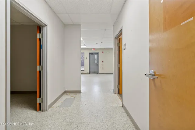 a view of a hallway with closet and a window