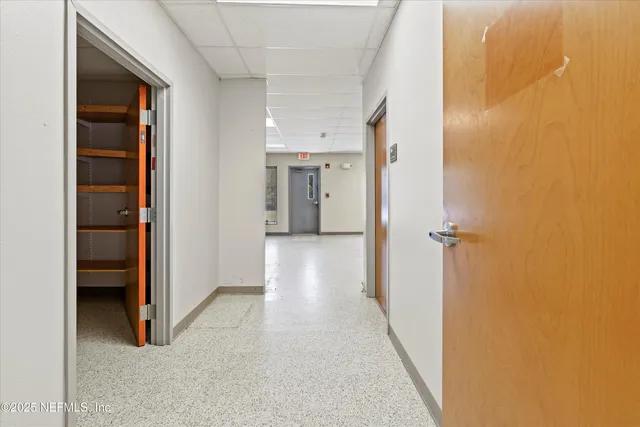 a view of a hallway with closet and a bathroom