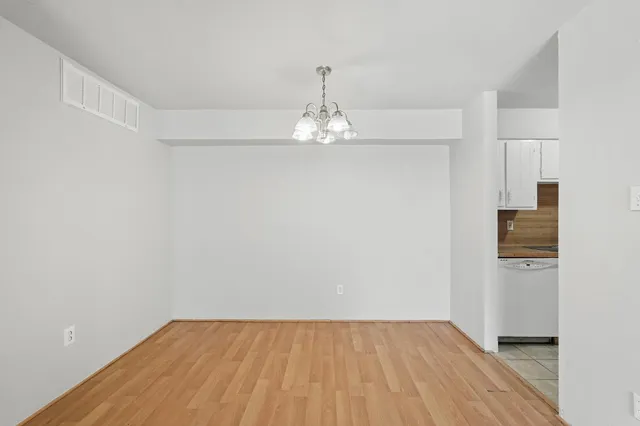a view of a room with wooden floor and a chandelier