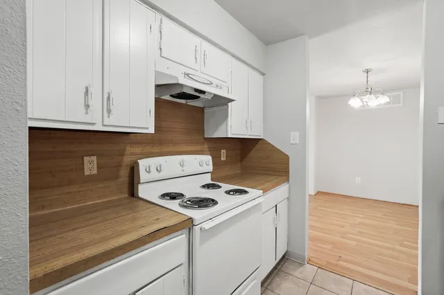 a kitchen with a stove and white cabinets