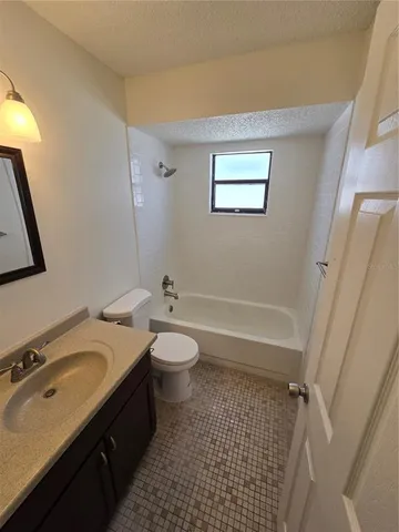 a bathroom with a sink a toilet a mirror and shower