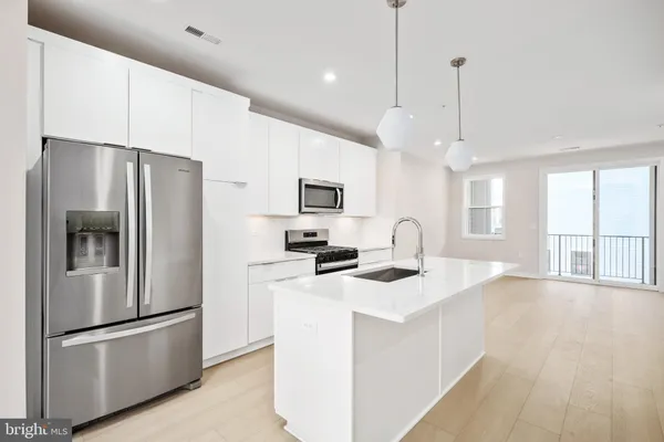 a kitchen with stainless steel appliances granite countertop a refrigerator a stove a sink and a refrigerator