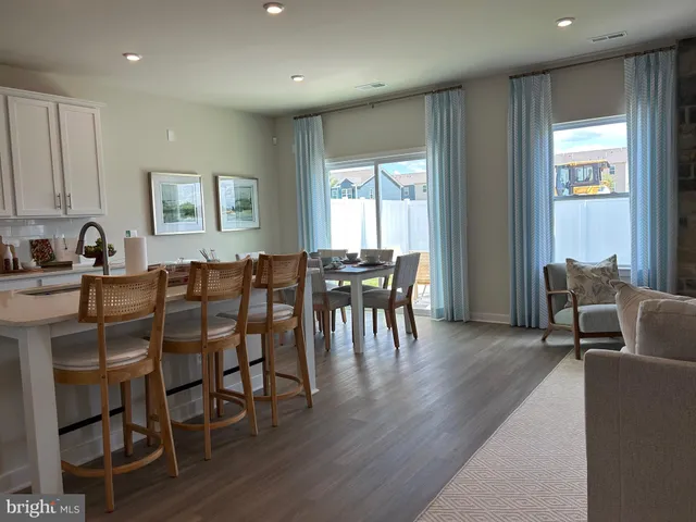 a view of a hallway with wooden floor and a living room