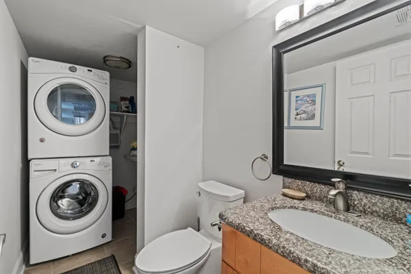 a bathroom with a granite countertop toilet sink and mirror