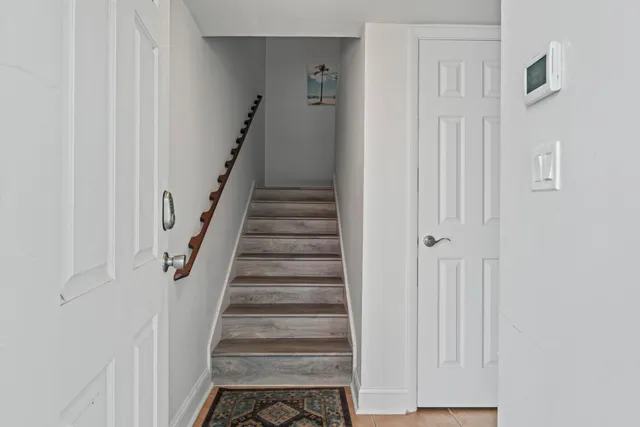 a view of staircase with white walls and white door