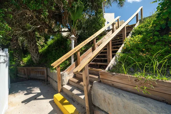 a view of a brick house with a small yard and plants