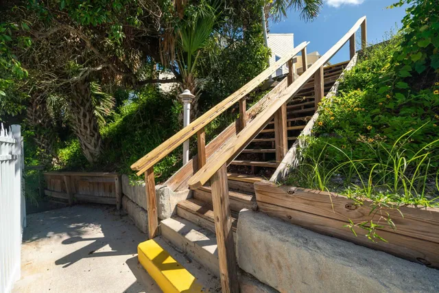 a view of a brick house with a small yard and plants