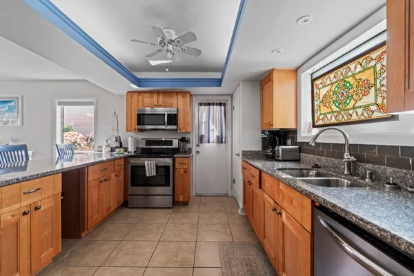 a large kitchen with stainless steel appliances granite countertop a stove and a sink