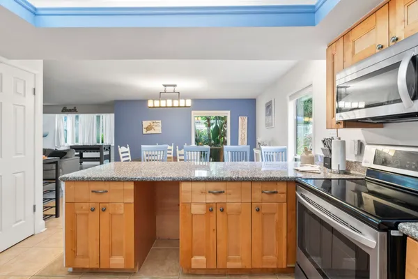 a kitchen with granite countertop cabinets stainless steel appliances a sink and a window