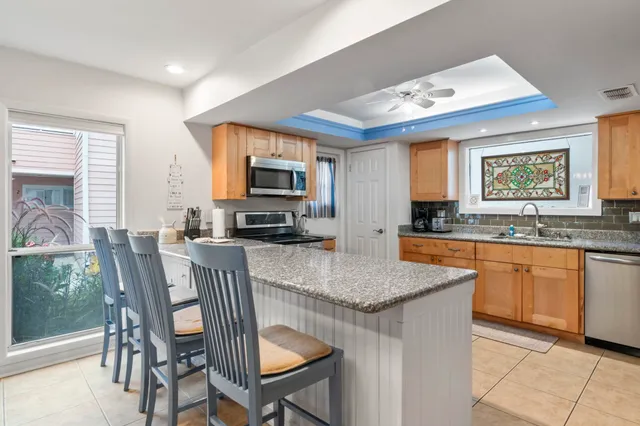 a kitchen with stainless steel appliances granite countertop a stove a sink a microwave a dining table and chairs