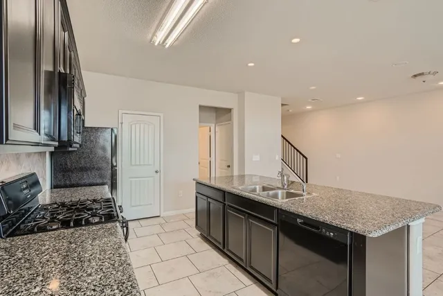 a kitchen with a sink a stove and cabinets