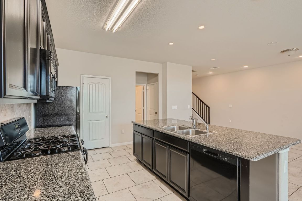 403 Epiphany Lane Pflugerville, TX 78660 - Photo 11 of 29 a kitchen with a sink a stove and cabinets