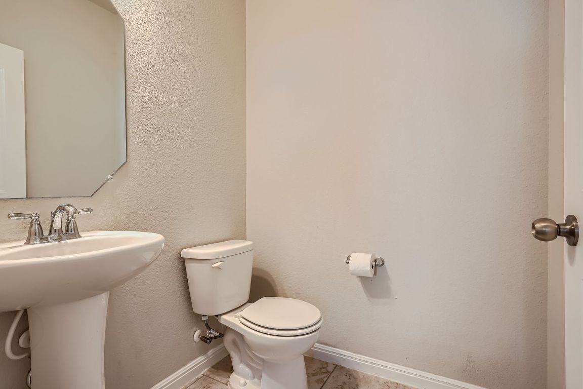 403 Epiphany Lane Pflugerville, TX 78660 - Photo 14 of 29 a bathroom with a toilet a sink and mirror
