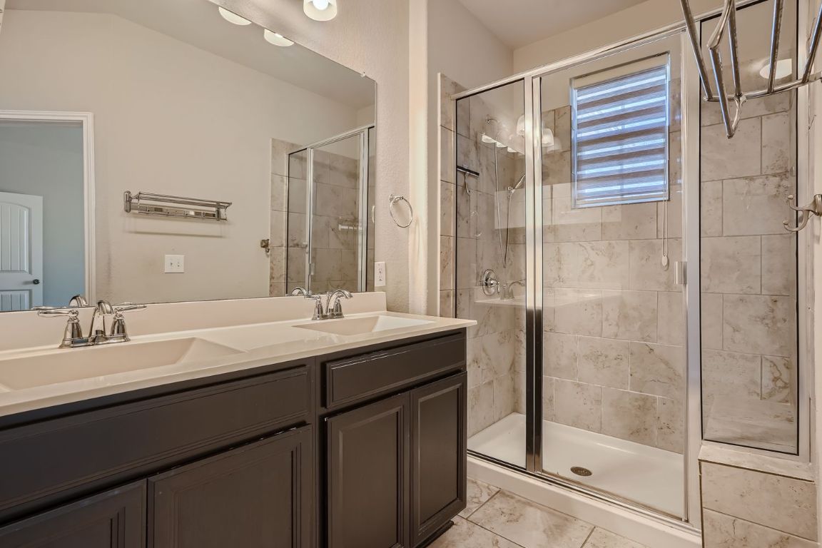 403 Epiphany Lane Pflugerville, TX 78660 - Photo 17 of 29 a bathroom with a double vanity sink mirror and shower